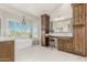 Luxurious primary bathroom with a freestanding tub, custom cabinets, and a stylish chandelier at 15237 S 19Th Way, Phoenix, AZ 85048