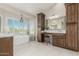 The stunning bathroom features a soaking tub, shuttered windows, and ample cabinet space at 15237 S 19Th Way, Phoenix, AZ 85048