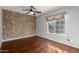 Bedroom with hardwood floors, a ceiling fan, and an accent wall behind the bed at 15237 S 19Th Way, Phoenix, AZ 85048
