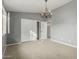 Spacious bedroom with neutral carpet, decorative chandelier, and closet with sliding doors at 15237 S 19Th Way, Phoenix, AZ 85048