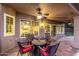 Covered patio with stone floor and ceiling fan features seating and view into home and yard at 15237 S 19Th Way, Phoenix, AZ 85048