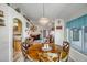 Open dining area with a large wooden table, decorative chandelier, and lots of light at 15558 N Ulrich Way, Surprise, AZ 85374