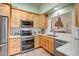 Well-lit kitchen with stainless steel appliances, light wood cabinets, and white countertops at 15558 N Ulrich Way, Surprise, AZ 85374