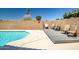 A refreshing in-ground pool and spacious deck area surrounded by lush greenery, perfect for outdoor enjoyment at 15558 N Ulrich Way, Surprise, AZ 85374