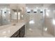 Bathroom featuring double sinks, a large mirror, and a frameless glass shower at 16689 W Whispering Wind Dr, Surprise, AZ 85387