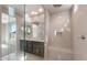 Bright bathroom with double sinks, large mirror, and a frameless glass shower with a seat at 16689 W Whispering Wind Dr, Surprise, AZ 85387