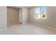 Bright, airy bedroom with neutral walls, tile floors, and a window overlooking the neighborhood at 16689 W Whispering Wind Dr, Surprise, AZ 85387