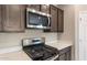 Close-up of the kitchen showcasing a gas range, microwave, and stainless-steel appliances at 16689 W Whispering Wind Dr, Surprise, AZ 85387