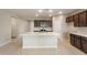 Open-concept kitchen with a large island, plenty of counter space, and modern appliances at 16689 W Whispering Wind Dr, Surprise, AZ 85387