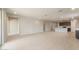 Open living room with ceramic tile flooring leading to kitchen and dining areas at 16689 W Whispering Wind Dr, Surprise, AZ 85387