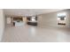 Open living room with ceramic tile flooring and view to the kitchen at 16689 W Whispering Wind Dr, Surprise, AZ 85387