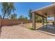 View of the gravel and grass backyard with a covered patio featuring ceiling fans at 17235 W Statler St, Surprise, AZ 85388