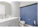 Half bathroom with updated vanity and gray walls with blue accent wall at 17235 W Statler St, Surprise, AZ 85388