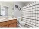 Bathroom featuring a wood vanity, decorative mirror, and a shower with patterned curtain at 17235 W Statler St, Surprise, AZ 85388