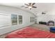 Bright bedroom featuring carpet flooring, two ceiling fans and large windows with blinds at 17235 W Statler St, Surprise, AZ 85388