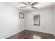 Bedroom with dark wood laminate flooring, ceiling fan, and a window at 17235 W Statler St, Surprise, AZ 85388