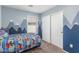 A cozy bedroom with Paw Patrol themed decor, carpet flooring and a double door closet at 17235 W Statler St, Surprise, AZ 85388