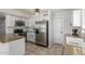 Well-lit kitchen with stainless steel refrigerator and microwave, white cabinets and tile flooring at 17235 W Statler St, Surprise, AZ 85388