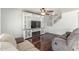 Living room featuring dark wood flooring, a ceiling fan, and a fireplace at 17235 W Statler St, Surprise, AZ 85388