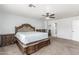 A large main bedroom with carpet floors, a ceiling fan and a carved, ornate bed at 17235 W Statler St, Surprise, AZ 85388
