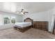 A large main bedroom with carpet floors, a ceiling fan and a carved, ornate bed at 17235 W Statler St, Surprise, AZ 85388