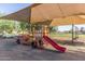 Playground with fire engine and slide sheltered by large sunshade, perfect for imaginative play at 17235 W Statler St, Surprise, AZ 85388