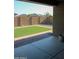 View of a green backyard and tall block fence from a covered patio at 17427 W Hadley St, Goodyear, AZ 85338