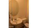 Bathroom featuring a single white sink, oval mirror, and toilet at 17427 W Hadley St, Goodyear, AZ 85338