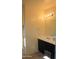 Bathroom vanity with dark cabinets, white countertop, sink, mirror and decorative lighting at 17427 W Hadley St, Goodyear, AZ 85338