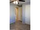 Bedroom with neutral paint, ceiling fan, tile flooring, and multiple doors at 17427 W Hadley St, Goodyear, AZ 85338