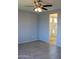 Bedroom with tile floors, neutral walls, ceiling fan, and an open bathroom at 17427 W Hadley St, Goodyear, AZ 85338
