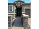 Covered entryway and brick lined walkway provides access to a screen door at 17427 W Hadley St, Goodyear, AZ 85338