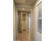 Hallway featuring tile flooring, neutral paint and open closet with shelving at 17427 W Hadley St, Goodyear, AZ 85338