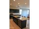 Modern kitchen featuring dark cabinetry, stainless steel appliances, and a spacious granite island with seating at 17427 W Hadley St, Goodyear, AZ 85338