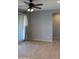 Open living room with tile flooring, neutral walls, and sliding glass doors at 17427 W Hadley St, Goodyear, AZ 85338