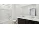 Bright bathroom featuring double sinks with dark cabinets and shower-tub combo at 1785 W Solstice Ave, Apache Junction, AZ 85120