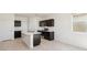 A kitchen with a large island, stainless steel appliances, and black cabinetry at 1785 W Solstice Ave, Apache Junction, AZ 85120
