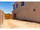 Spacious backyard with wood gate and a view of the home's side entrance at 18663 W Vogel Ave, Goodyear, AZ 85338