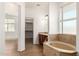Bright bathroom with soaking tub, dual vanities, and walk-in closet at 18663 W Vogel Ave, Goodyear, AZ 85338