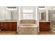 Luxurious bathroom featuring a garden tub, double vanity, and natural light at 18663 W Vogel Ave, Goodyear, AZ 85338