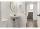 Bathroom with modern sink, mirror and towel ring next to an entryway to a stairway at 18663 W Vogel Ave, Goodyear, AZ 85338