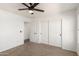 This bedroom is enhanced by a ceiling fan, neutral carpet, closet, and entry to bathroom at 18663 W Vogel Ave, Goodyear, AZ 85338