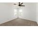Neutral carpet, a ceiling fan, and natural light from two windows enhance this bedroom at 18663 W Vogel Ave, Goodyear, AZ 85338