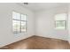 Bright bedroom with tile flooring, neutral walls, and natural light from two windows at 18663 W Vogel Ave, Goodyear, AZ 85338