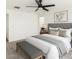 Chic bedroom featuring a tufted headboard, soft neutral tones, and a bench seat at the foot of the bed at 18663 W Vogel Ave, Goodyear, AZ 85338