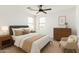 This modern bedroom features neutral tones, plush bedding, a ceiling fan and great natural light at 18663 W Vogel Ave, Goodyear, AZ 85338