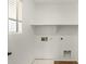 Laundry room with a window and shelving at 18663 W Vogel Ave, Goodyear, AZ 85338