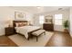Bright main bedroom with wood furniture, a white bed, and large windows at 18663 W Vogel Ave, Goodyear, AZ 85338