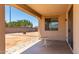 Covered patio with a small table and brick-paved flooring, offering a relaxing outdoor space at 18663 W Vogel Ave, Goodyear, AZ 85338