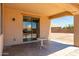 Covered patio with a table, sliding glass door, and lighting, perfect for outdoor relaxation at 18663 W Vogel Ave, Goodyear, AZ 85338